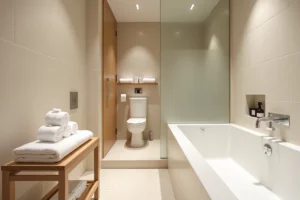 Salle de bain japonaise d'hôtel avec baignoire ofuro, douche séparée, accessoires en bois hinoki et serviettes pliées